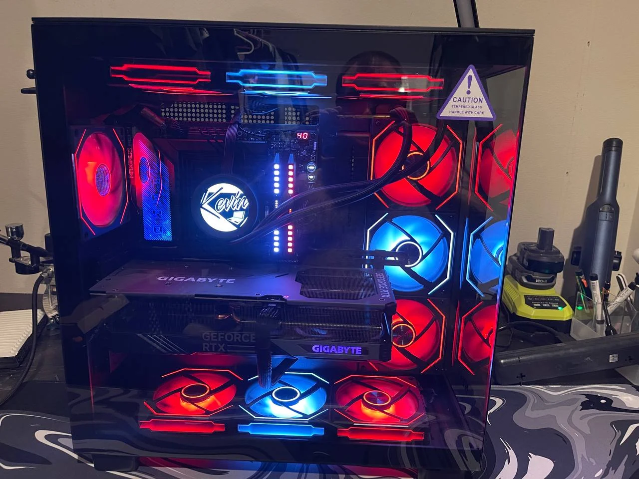 Custom PC with red and blue lighting and a Kevin’s display on its liquid cooler